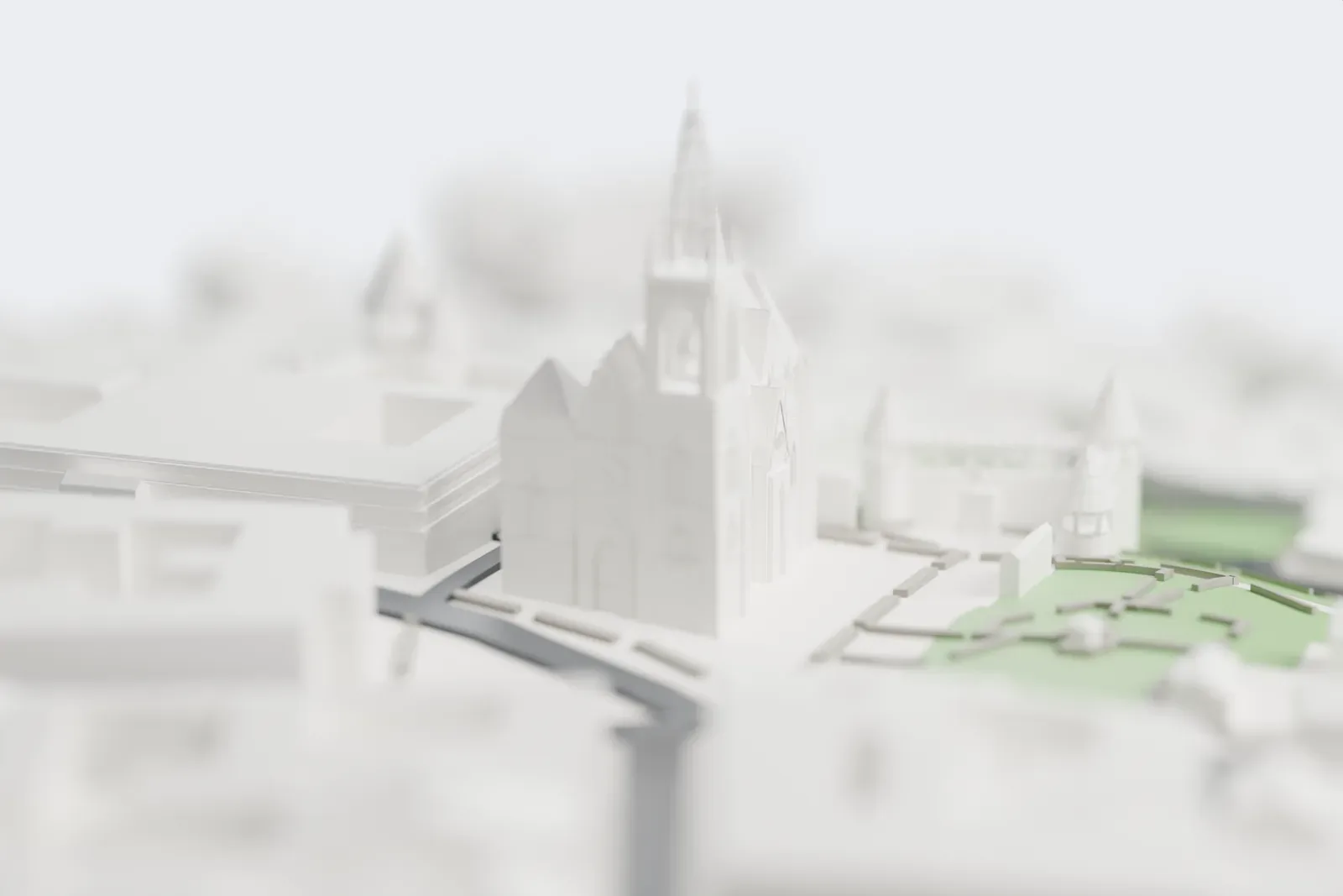 A white 3D print of Fisherman's Bastion, a low terraced wall of arcades with several cone-roofed towers, set in a green park beside a large church with a tall spire, a winding road and nearby buildings.