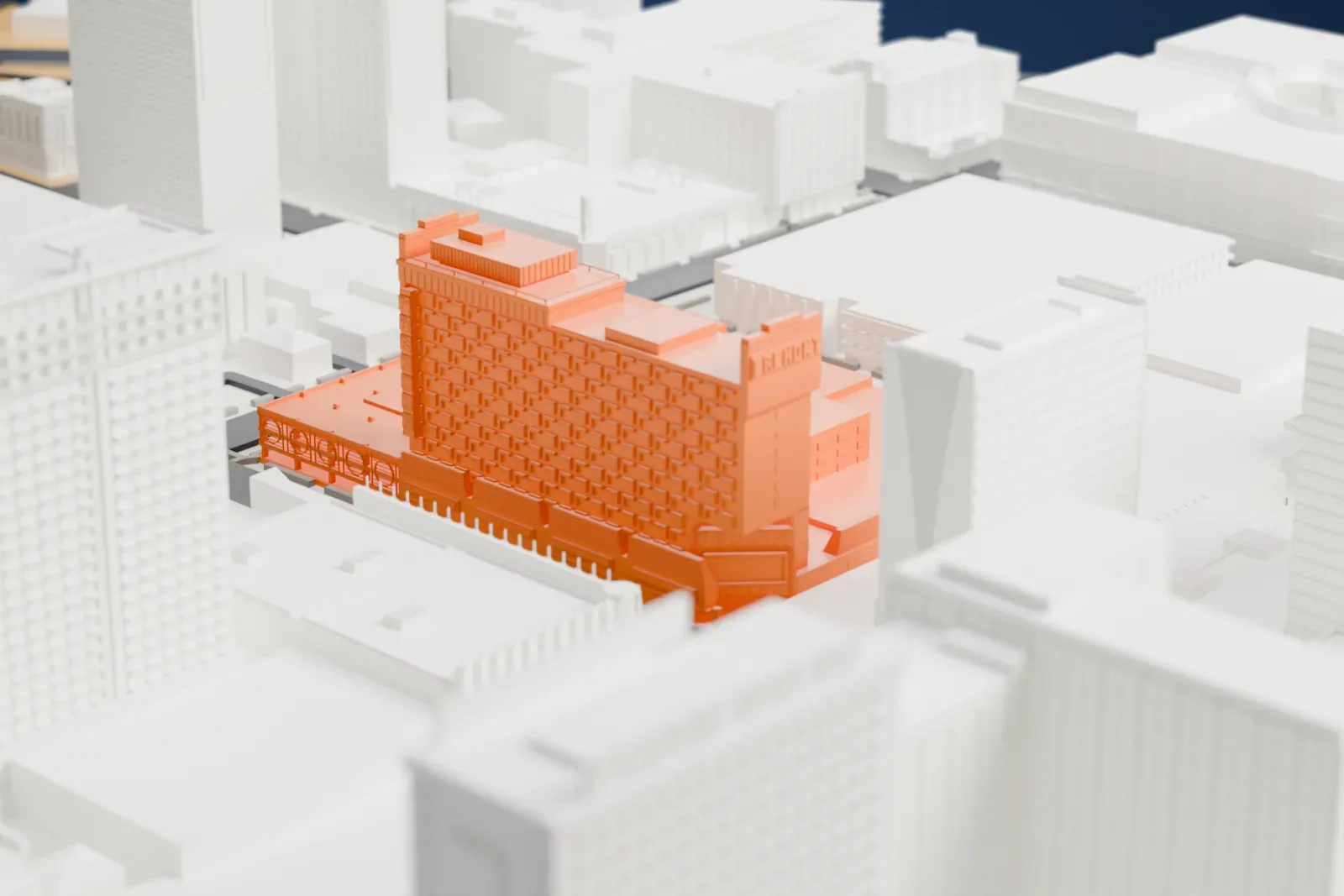 A white 3D print of the Fremont Hotel and Casino, a tall hotel block with a grid of windows rising above a wide low base, surrounded by taller and lower downtown buildings and narrow streets.