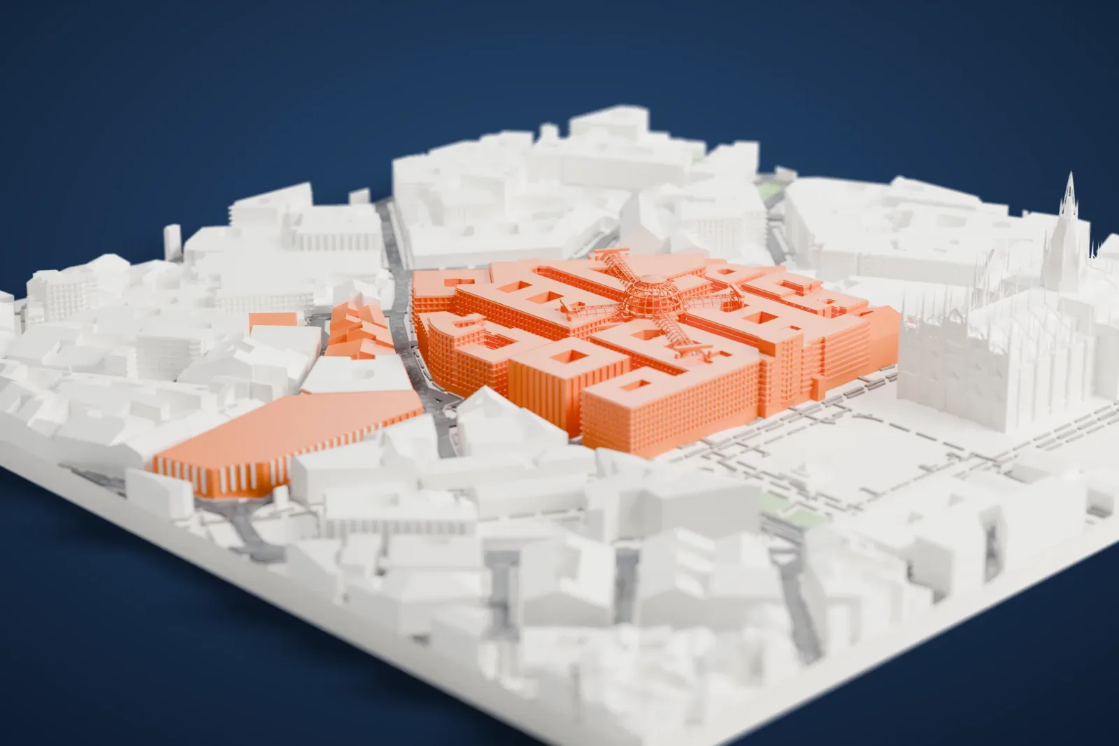 A white 3D print of the Galleria Vittorio Emanuele II, a cross-shaped ribbed roof with a central dome, set among dense city blocks beside a building with many spires.