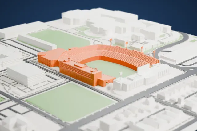A white 3D print of Gerald J. Ford Stadium, a horseshoe-shaped stadium with tiered stands and light towers around a green field, with houses and streets around it.