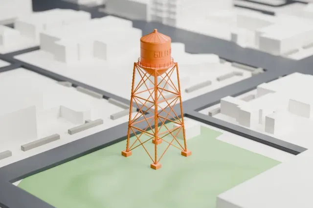 A white 3D print of the Gilbert Water Tower model in Gilbert, with the streets around it.