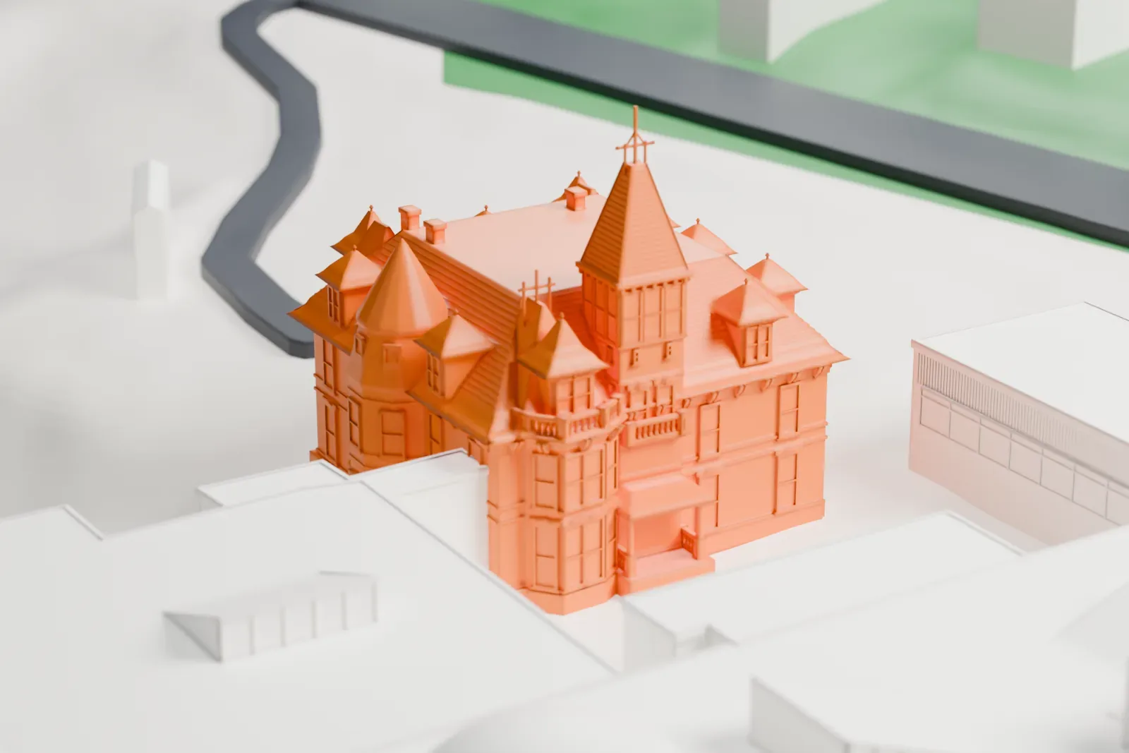 A white 3D print of Glenview Mansion, a Victorian stone house with a tall pyramid-roofed tower, a conical turret and many dormers, beside larger buildings.