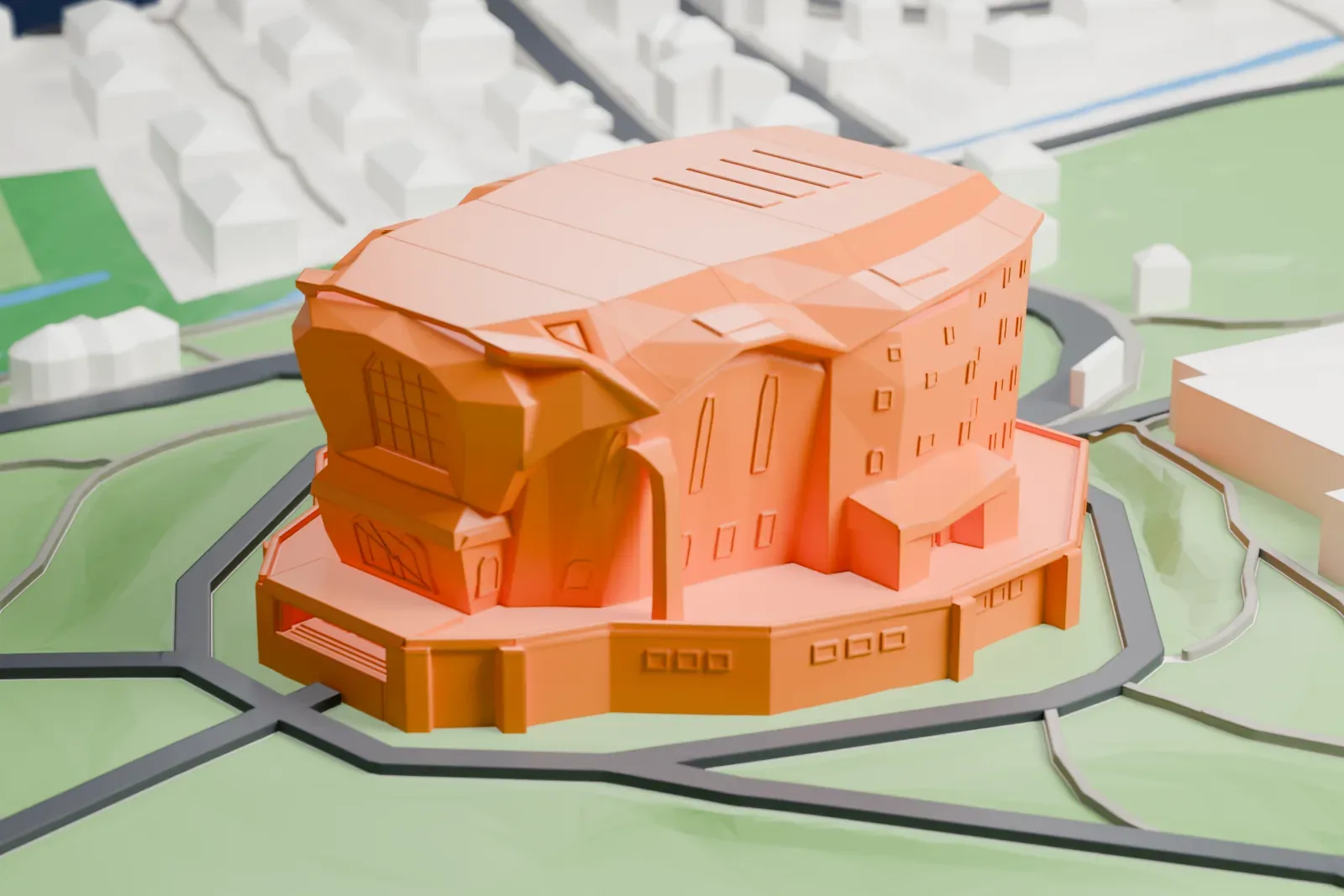 A white 3D print of the Goetheanum, with its broad folded roof and sculpted concrete front, standing among surrounding buildings.