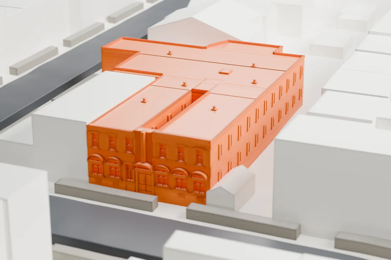 A white 3D print of Gottscheer Hall, a low, wide building with several flat roofs, set among taller neighboring buildings on a city block.