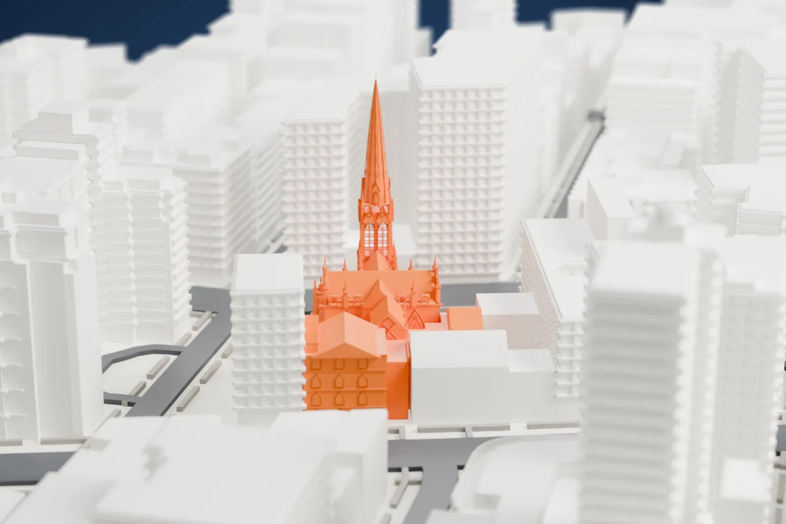 A white 3D print of Grace Church, its tall spire rising above the surrounding city blocks and streets.