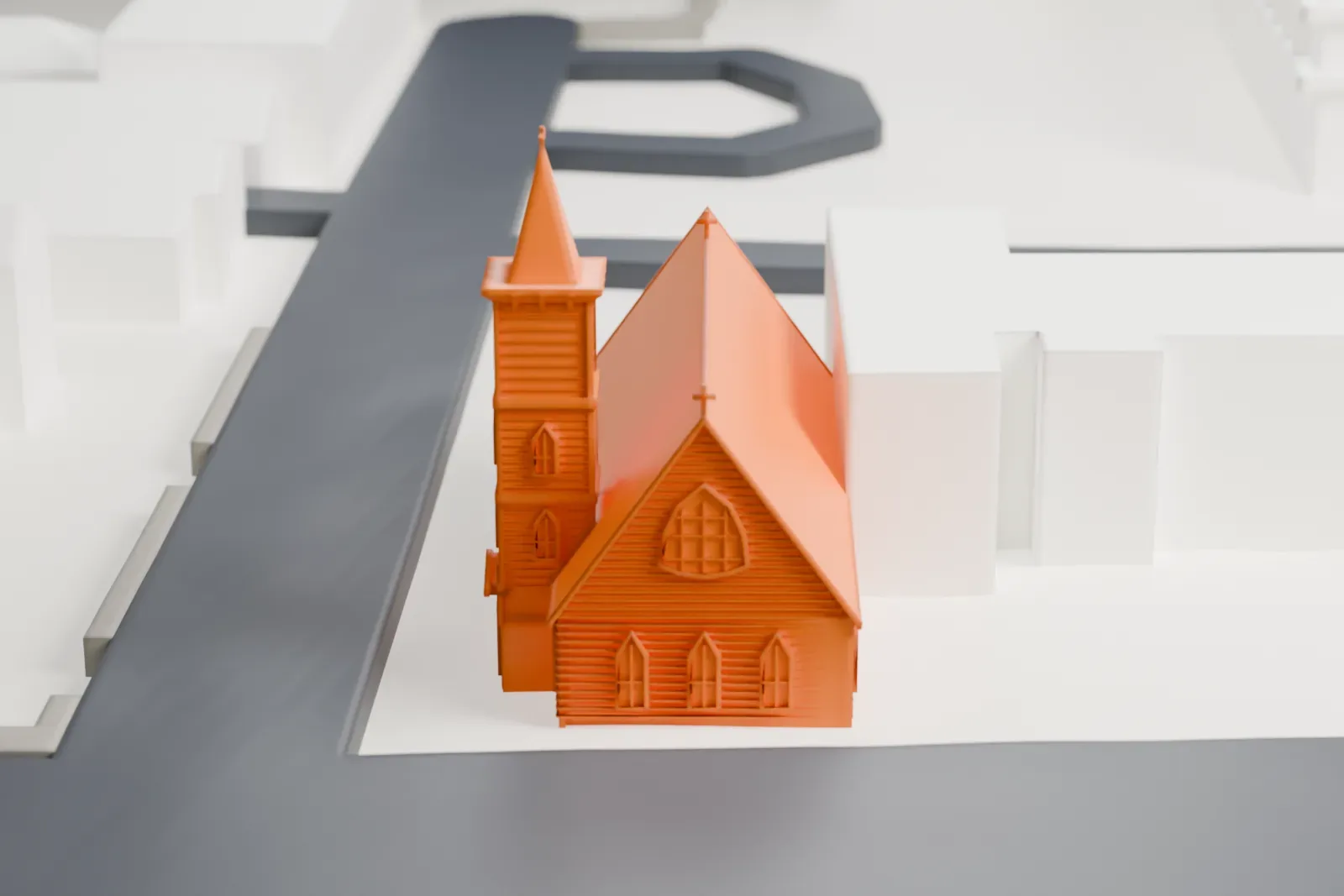 A white 3D print of Grace Episcopal Church, a small gabled church with a tall spire, on a corner lot between streets and nearby houses.
