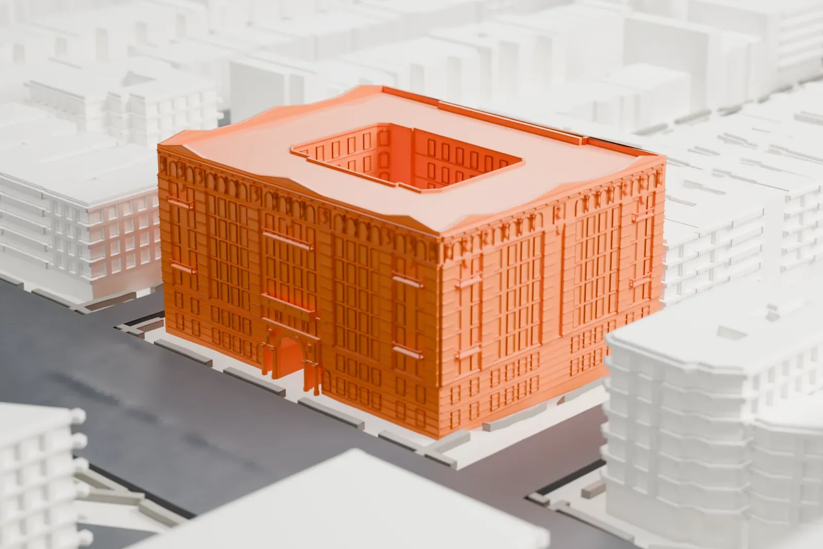 A white 3D print of Graham Court, a boxy block with an open courtyard in its center, among lower buildings, streets and a small green triangle.