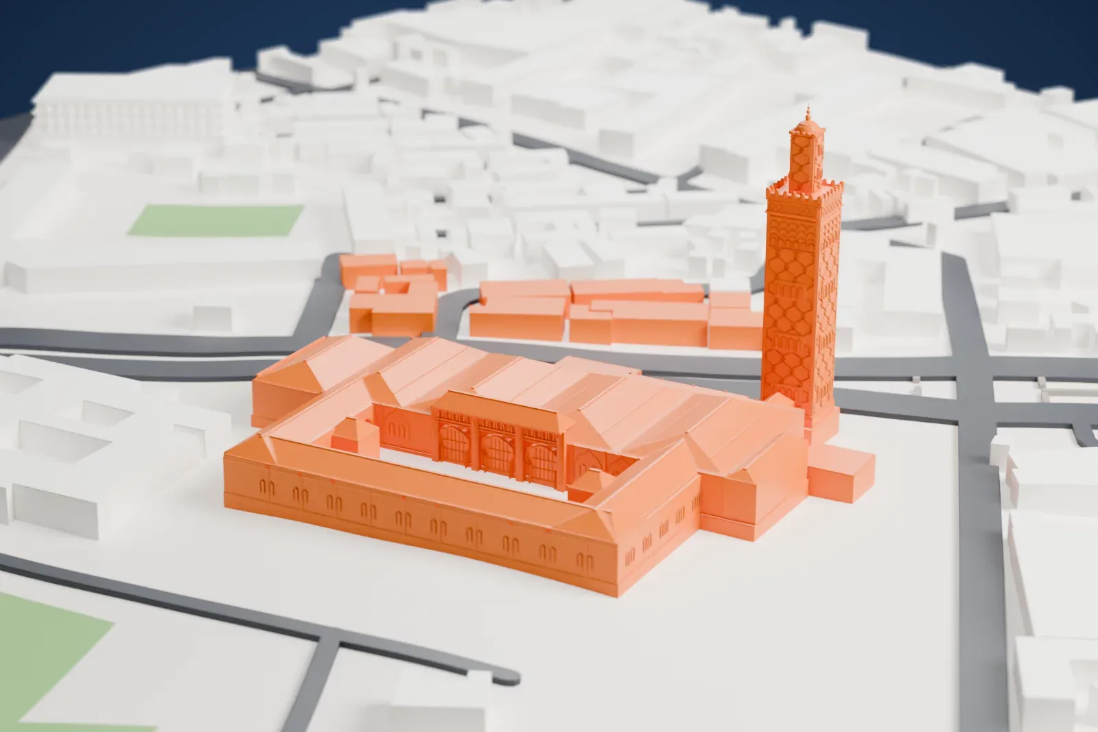 A white 3D print of the Grand Mosque of Dakar, a mosque of pitched roofs around an open courtyard with a tall patterned minaret beside it, among low city buildings.