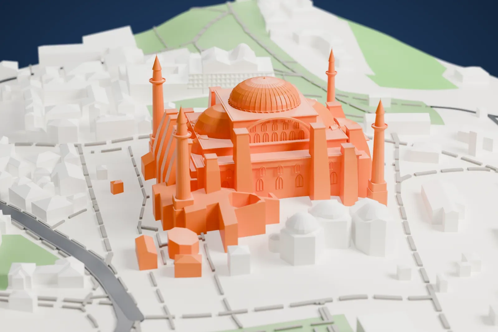 A white 3D print of Hagia Sophia, with its central dome, smaller domes, buttresses and slender minarets, surrounded by Istanbul streets, small parks and low buildings.