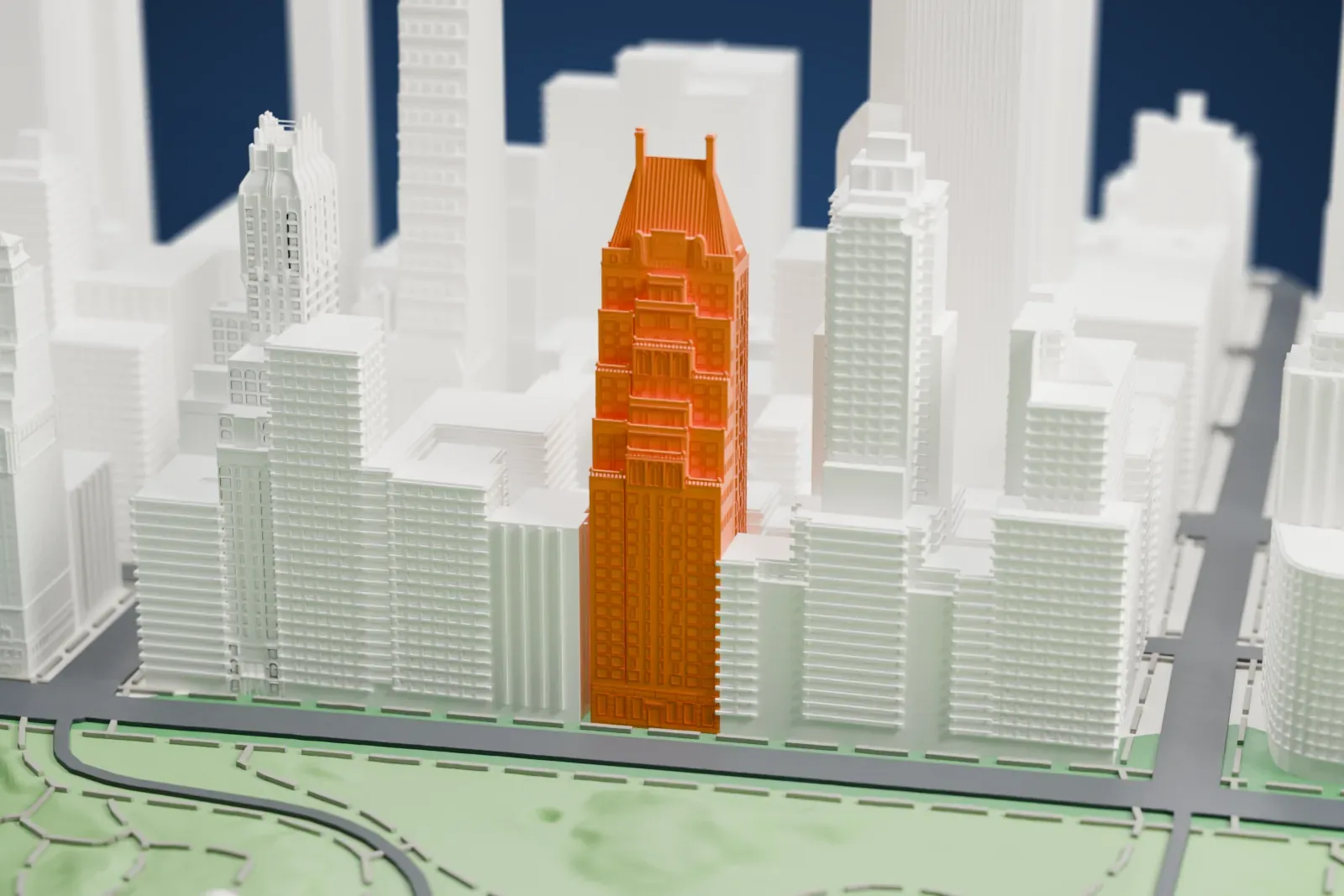 A white 3D print of Hampshire House, a tall, narrow tower with a steep roof, standing beside Central Park among taller skyscrapers.