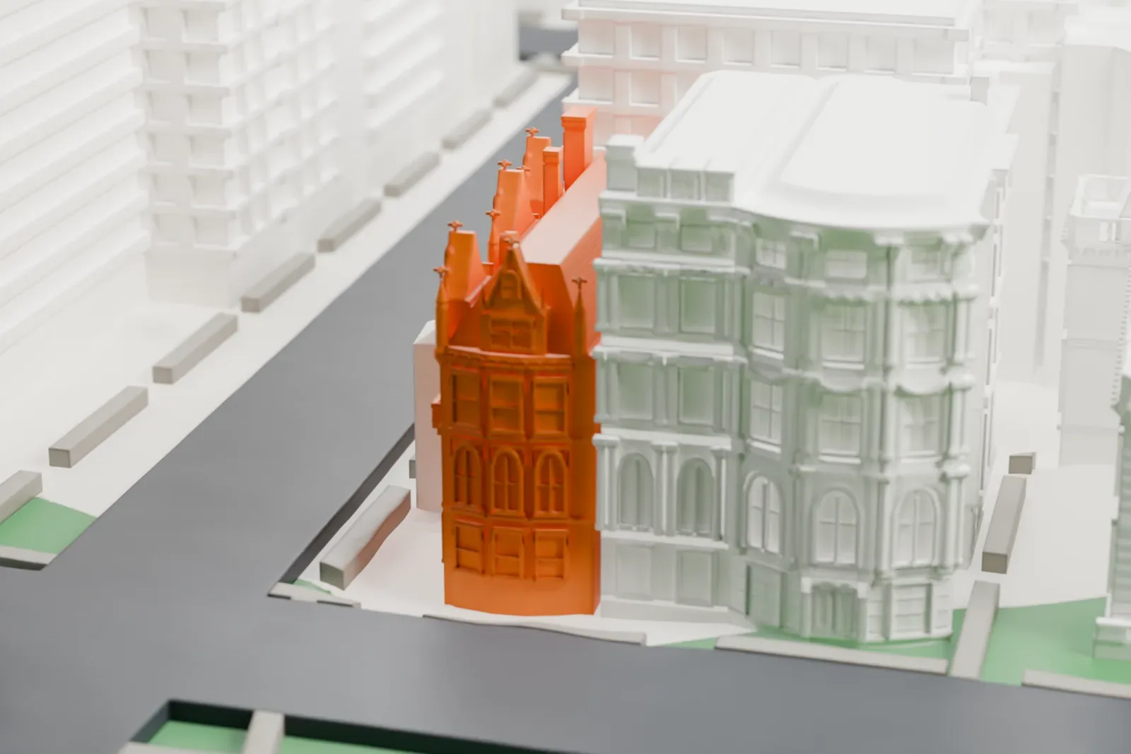 A white 3D print of the Harry F. Sinclair House, a narrow ornate mansion with a gabled front, standing at a street corner beside a park and taller buildings.