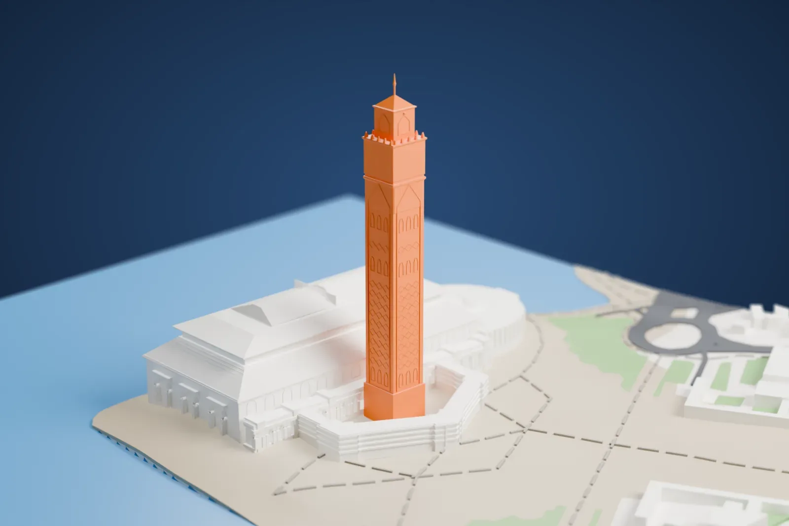 A white 3D print of the Hassan II Mosque, a broad hall with a tiered roof and a very tall square minaret beside it, on a promontory with the sea on three sides.