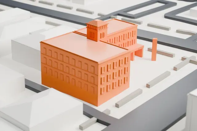 A white 3D print of the Hassayampa Inn, a wide, rectangular hotel with a small stepped tower and a slim entrance canopy, among low city blocks and streets.