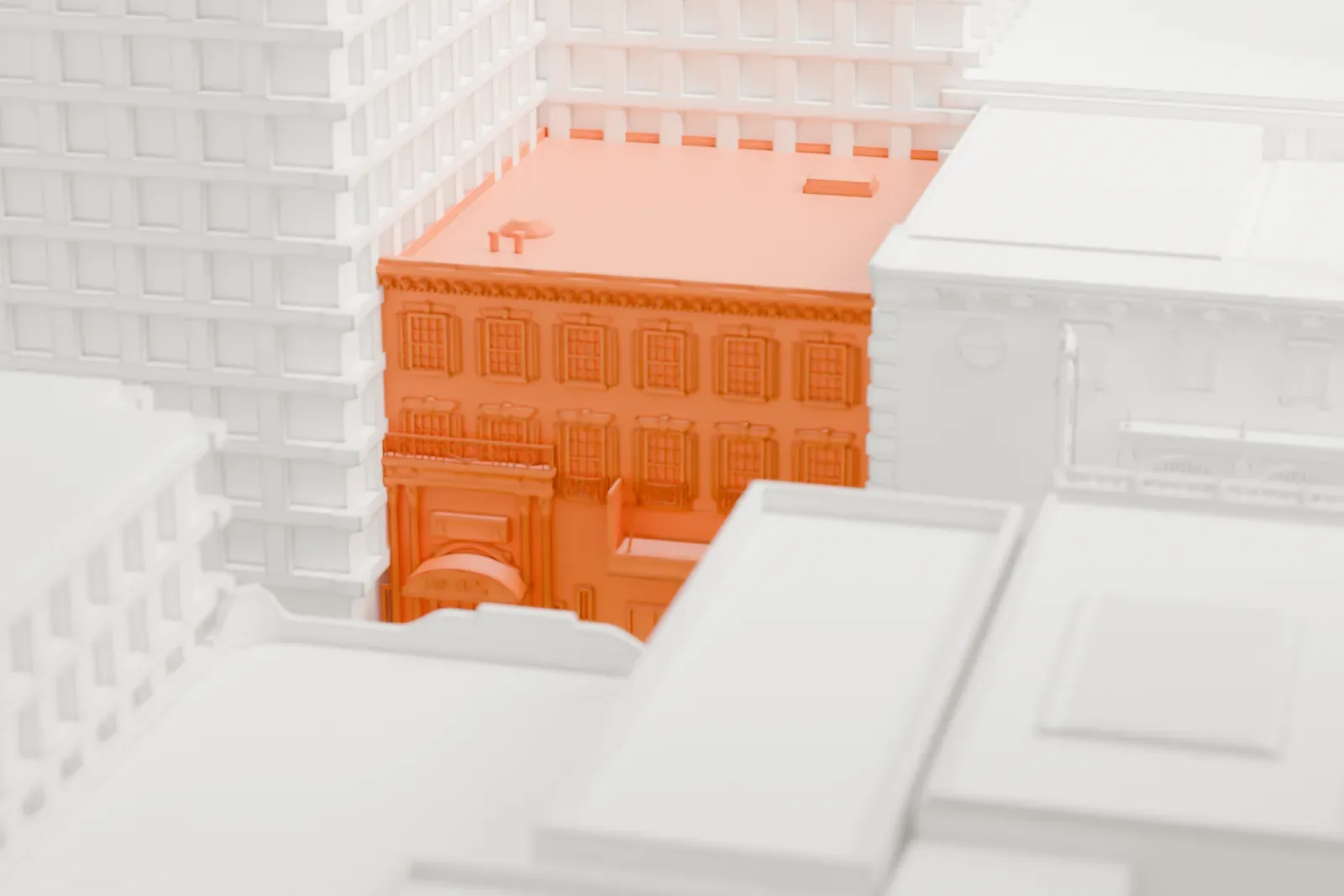 A white 3D print of the Hayes Theater, a small building almost hidden between the tall towers of Midtown Manhattan.