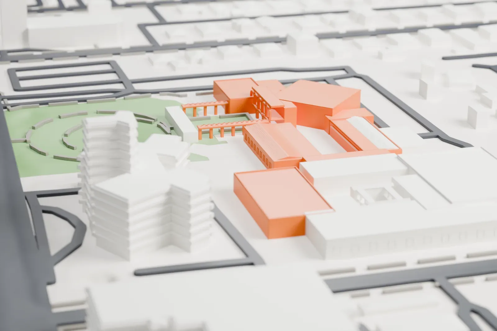 A white 3D print of the Heard Museum, a low cluster of flat-roofed blocks with slatted walkway covers, beside a green circular area and surrounded by streets and low buildings.