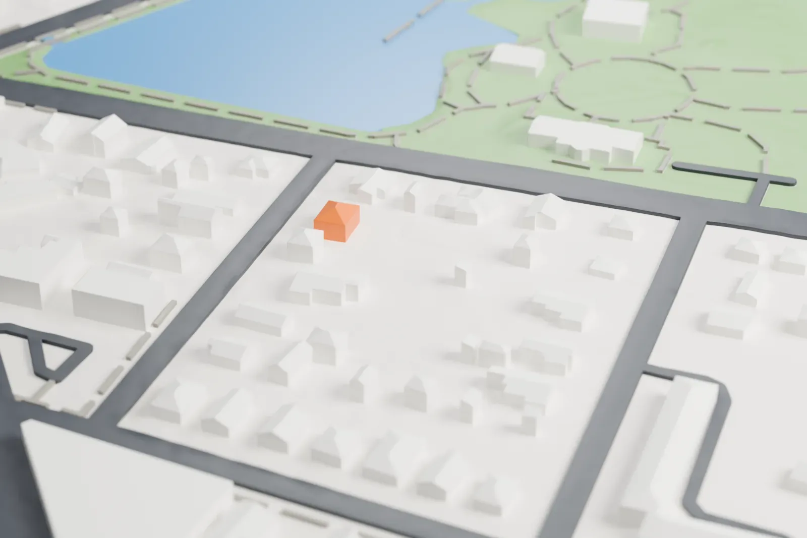 A white 3D print of the Heckscher Museum of Art, a low rectangular building with rounded corner bays and rooftop skylights, set in a park with winding paths, a pond and nearby roads.
