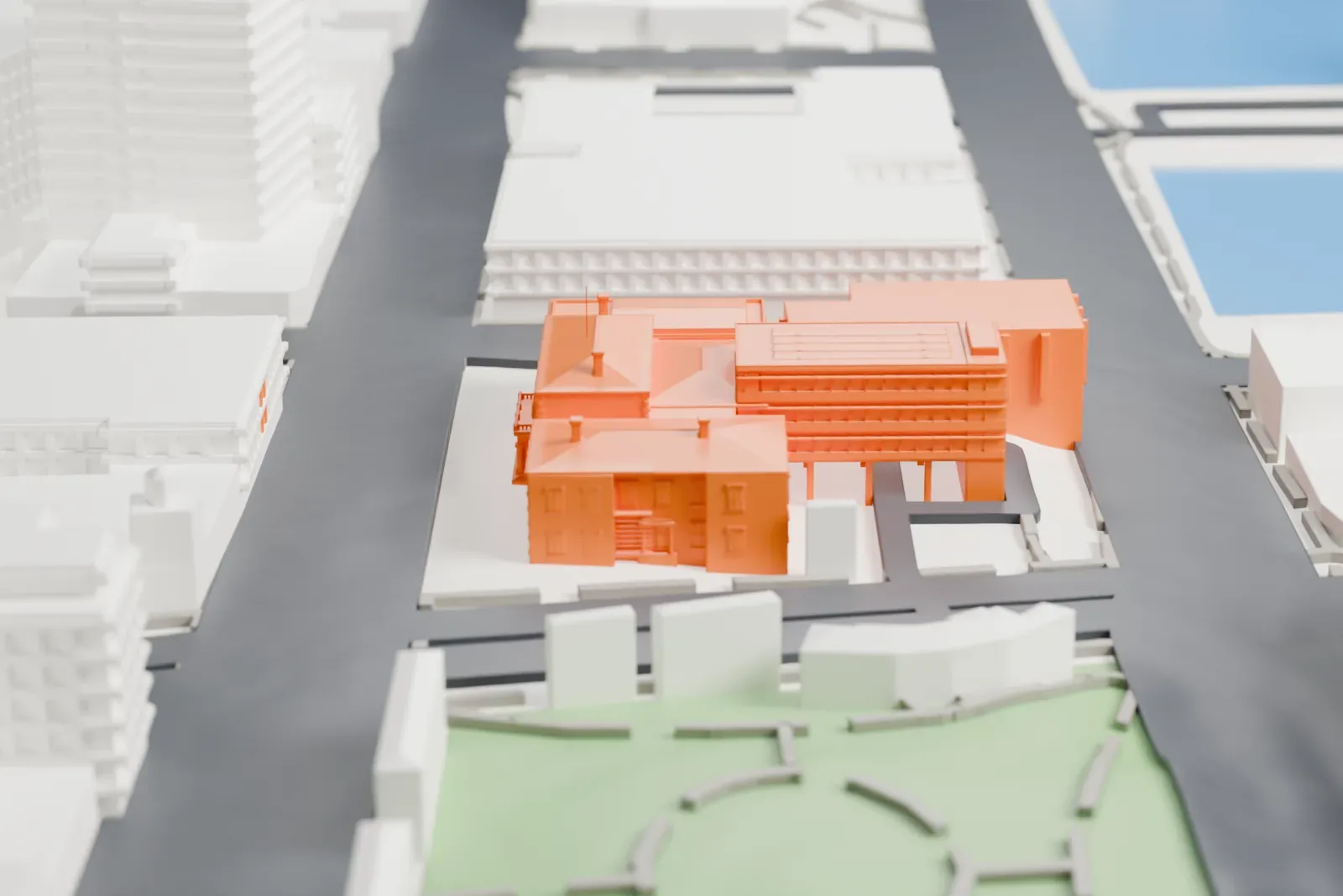 A white 3D print of Hobart Town Hall, a cluster of connected wings with a columned portico, among larger buildings and streets, with water beyond.