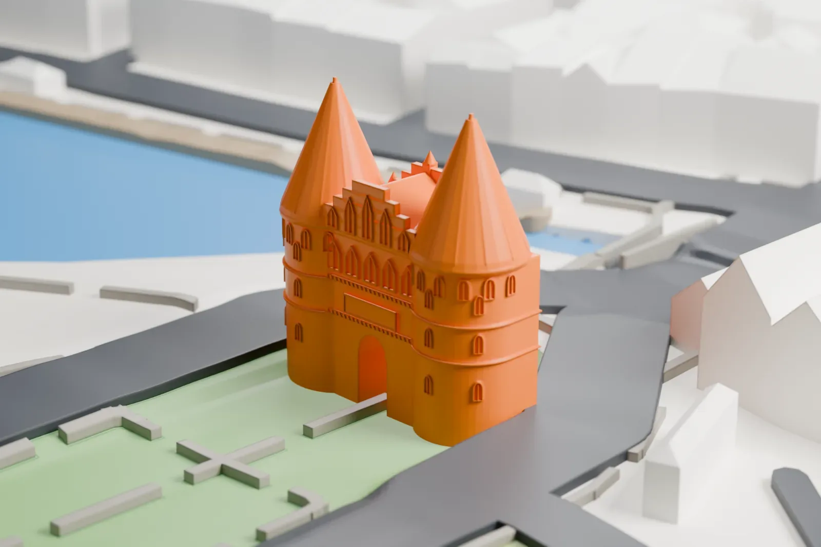 A white 3D print of the Holstentor with twin pointed roofs and an arched passage, surrounded by streets, green space, buildings, and water.