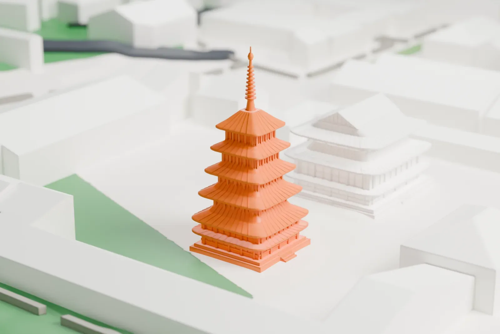 A white 3D print of Horyu-ji, a five-story pagoda with a slender finial beside a two-story hall with layered roofs, set among low buildings, paths and green ground.