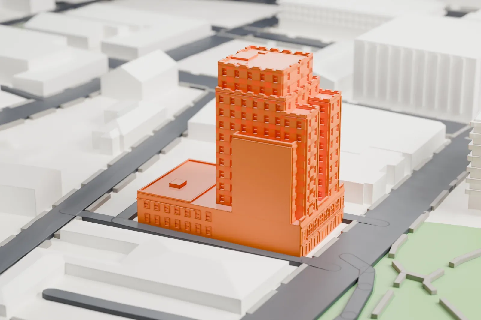 A white 3D print of Hotel Beach, a tall stepped tower with a lower wing beside it, standing among low buildings, streets and a patch of green space.