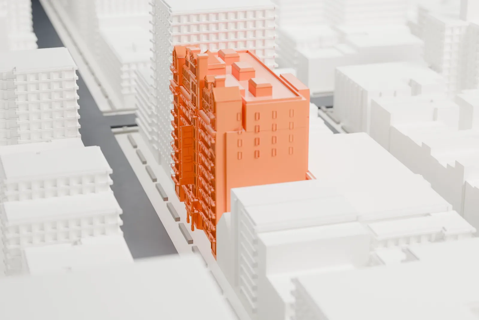 A white 3D print of the Hotel Chelsea, a tall brick-fronted building with gables and chimneys along its roofline, standing among dense blocks of taller and lower buildings.