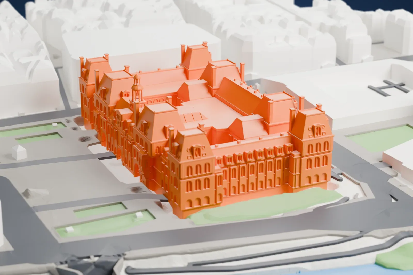 A white 3D print of the Hôtel de Ville, a long city hall with a central tower and corner pavilions, among the streets and buildings of central Paris.
