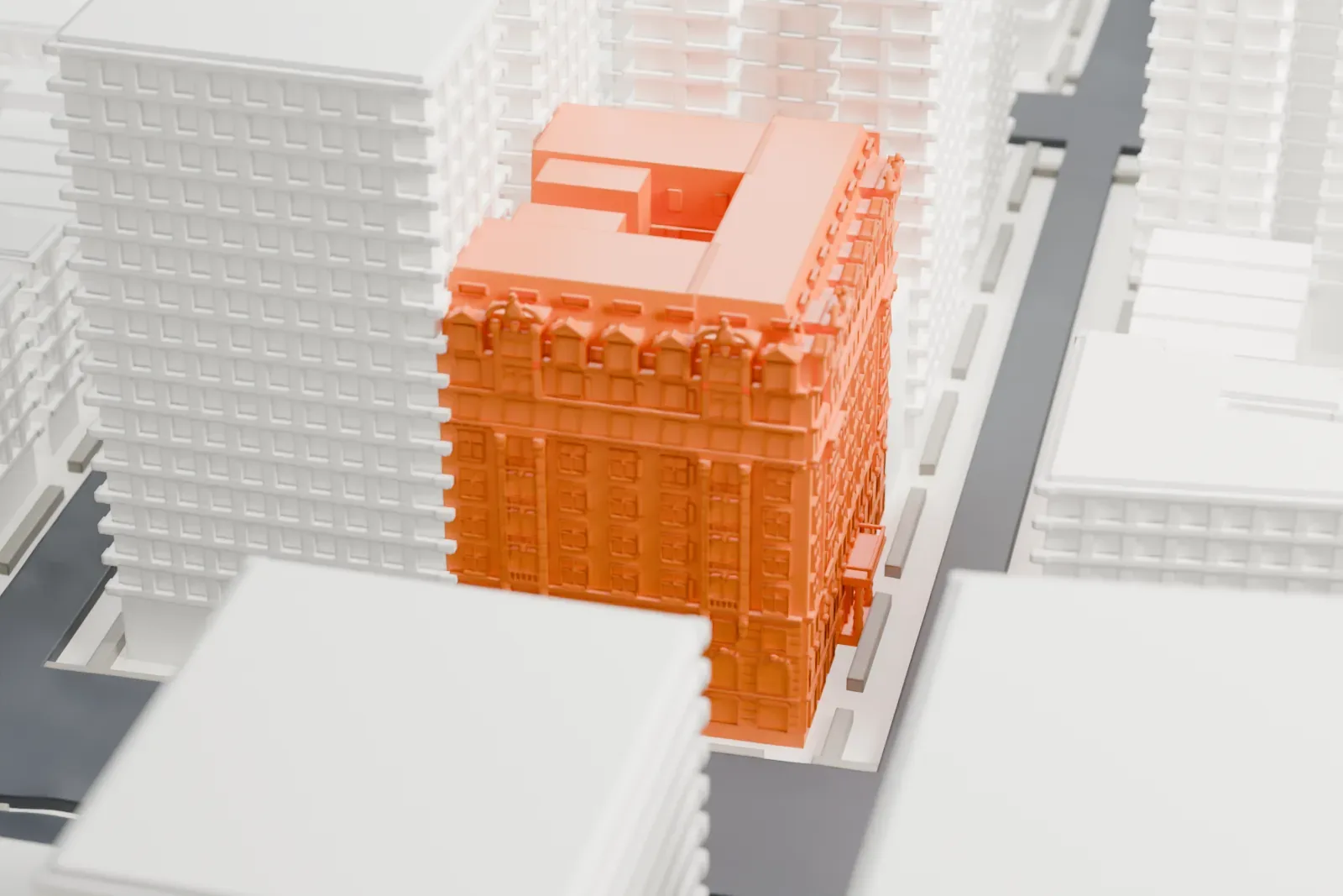 A white 3D print of the Hotel Marseilles, a tall corner building with an ornate decorated top and a stepped roof, closely surrounded by taller and lower buildings along city streets.