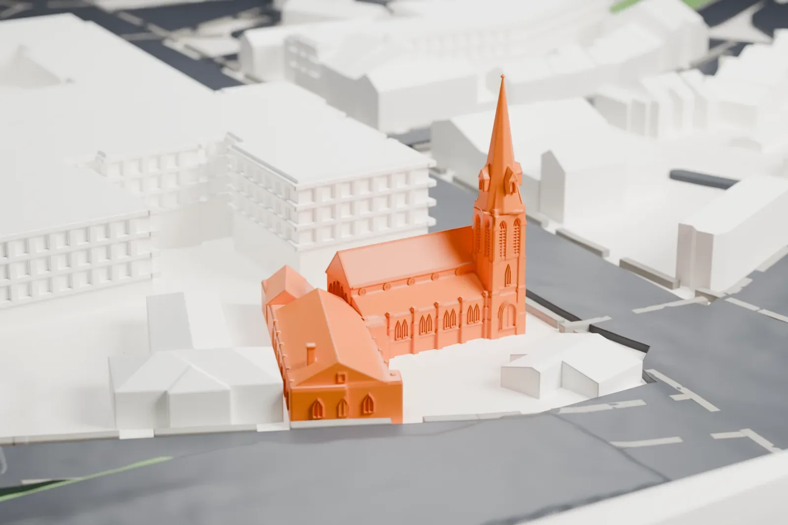 A white 3D print of the House of Prayer Episcopal Church and Rectory, a church with a tall spire joined to a long low wing, on a street corner with nearby buildings.
