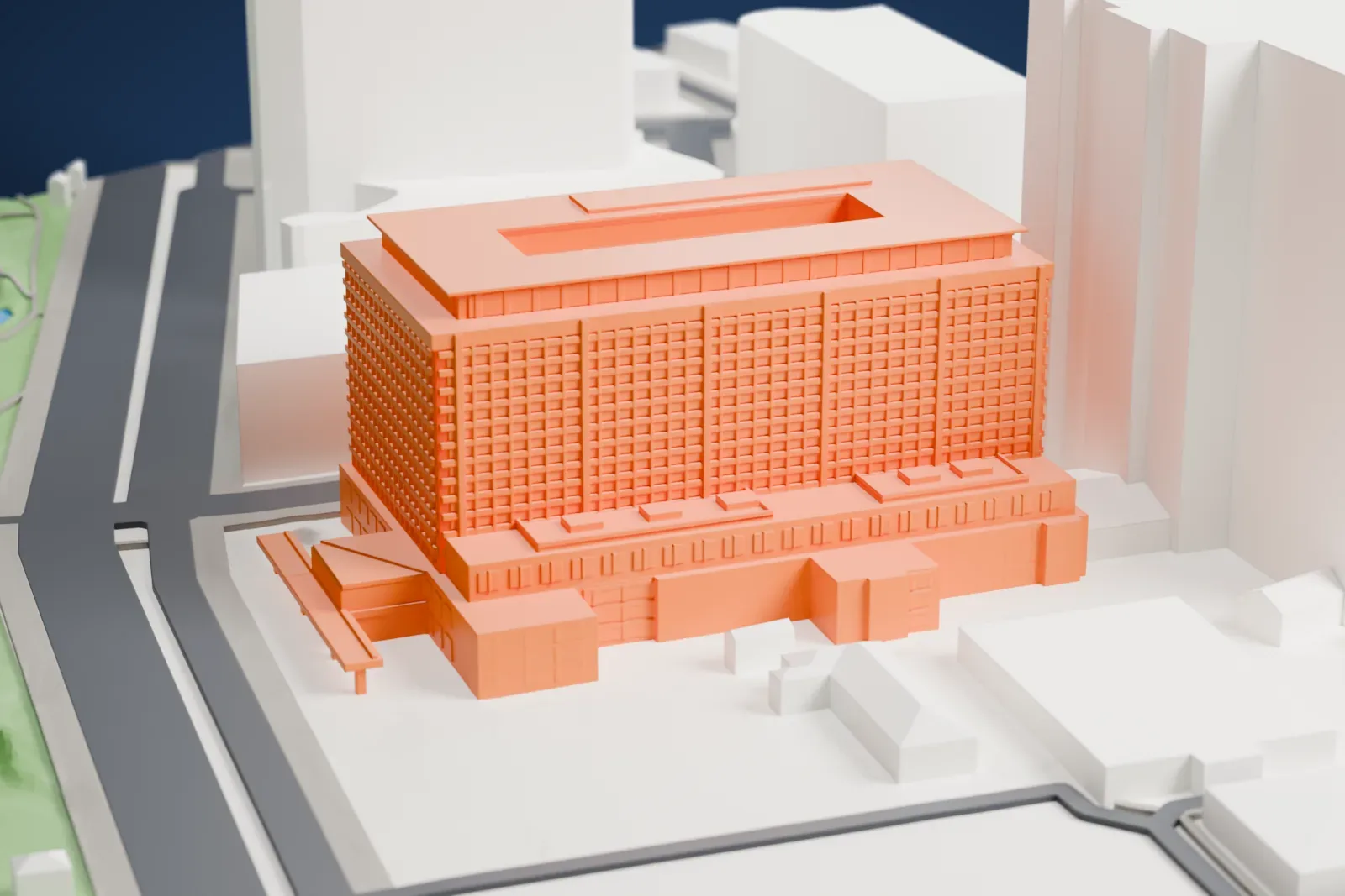 A white 3D print of the Imperial Hotel, a large hotel block standing among the streets and buildings around it.