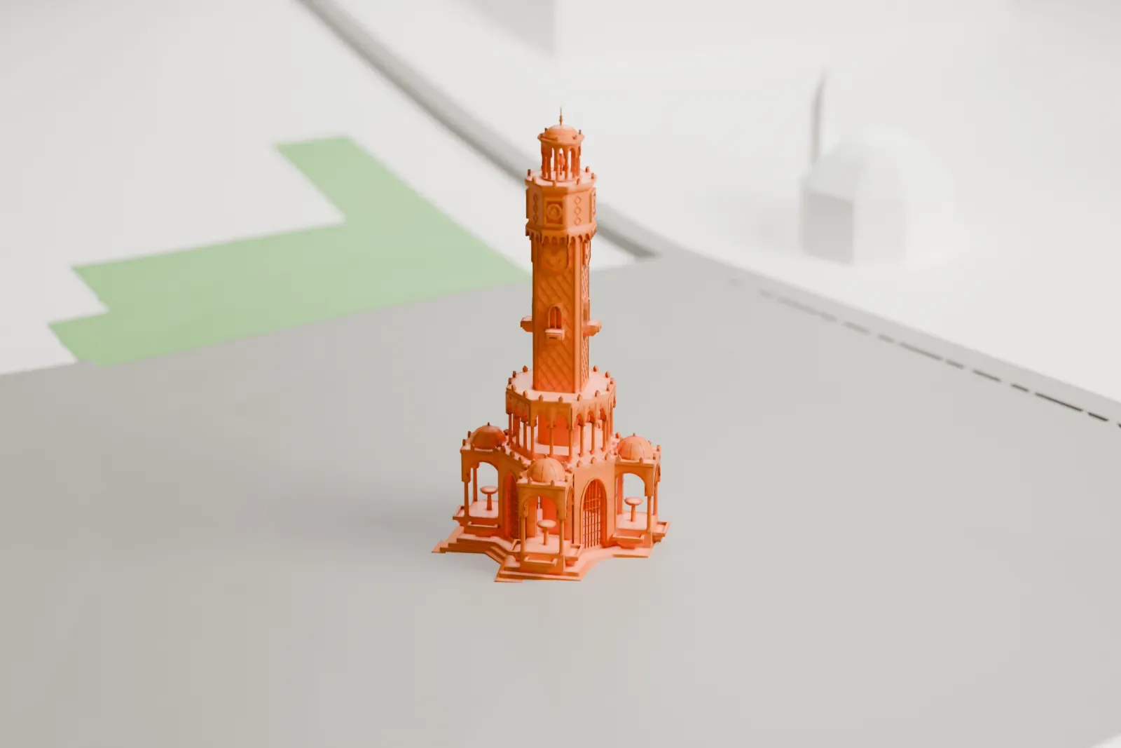 A white 3D print of the İzmir Clock Tower, with its four fountain pavilions and crescent finial, standing among surrounding streets and buildings.
