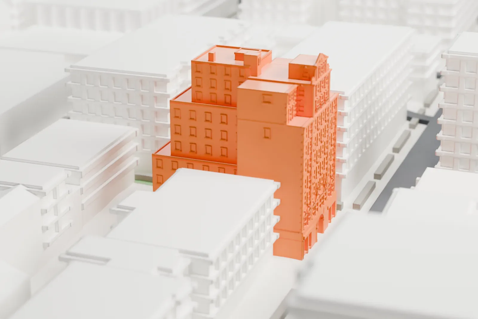 A white 3D print of the Jamaica Chamber of Commerce Building, a tall stepped brick tower rising above lower neighboring buildings on city blocks.