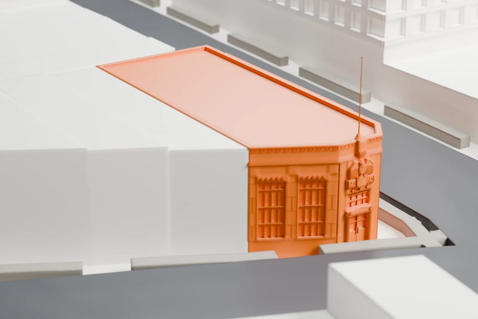A white 3D print of the Jamaica Savings Bank Building, a corner building with a flagpole on its roof, surrounded by taller neighboring buildings and streets.
