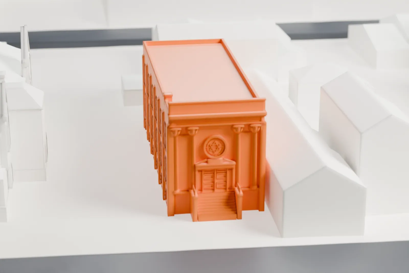 A white 3D print of the Jewish Museum of New Jersey, a two-story building with a columned entrance and steps, beside neighboring buildings.