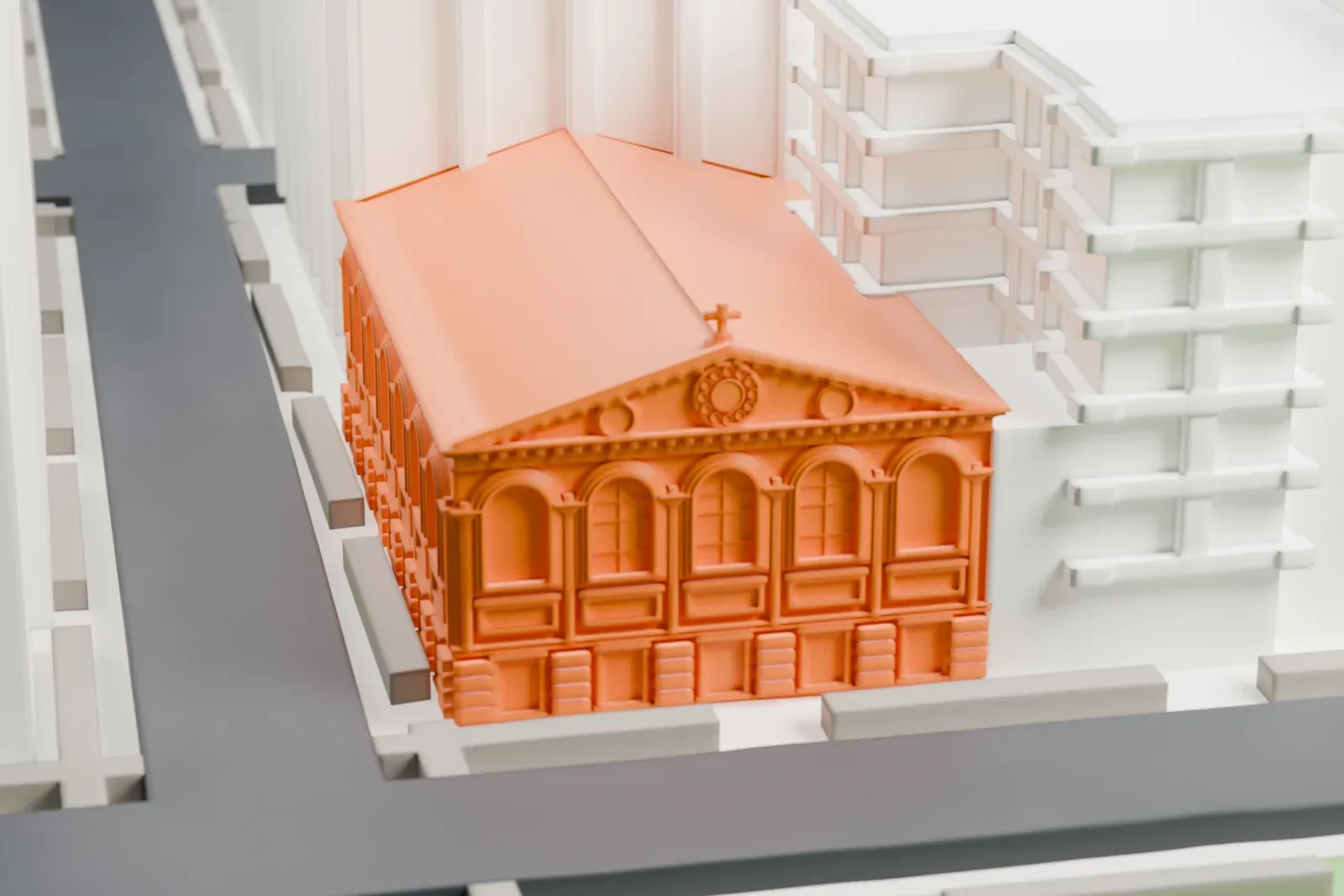 A white 3D print of Judson Memorial Church, a pedimented building with arched windows and a long gabled roof, beside streets and a park.