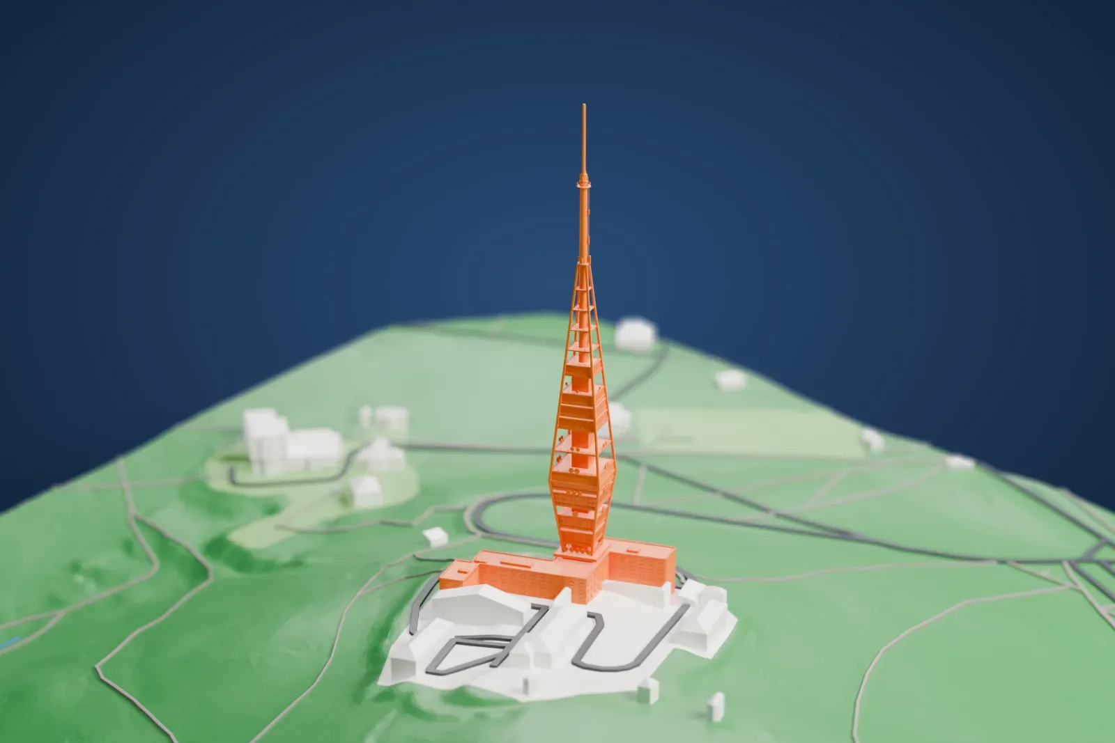 A white 3D print of the Kamzík TV Tower, a tall tower with slanted ribs and a thin mast, standing on a wooded hill beside a group of low buildings.