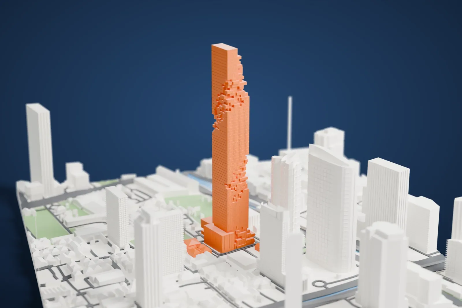 A white 3D print of King Power Mahanakhon, a slim square tower with stepped, notched sides, rising above lower buildings, roads and small patches of park.