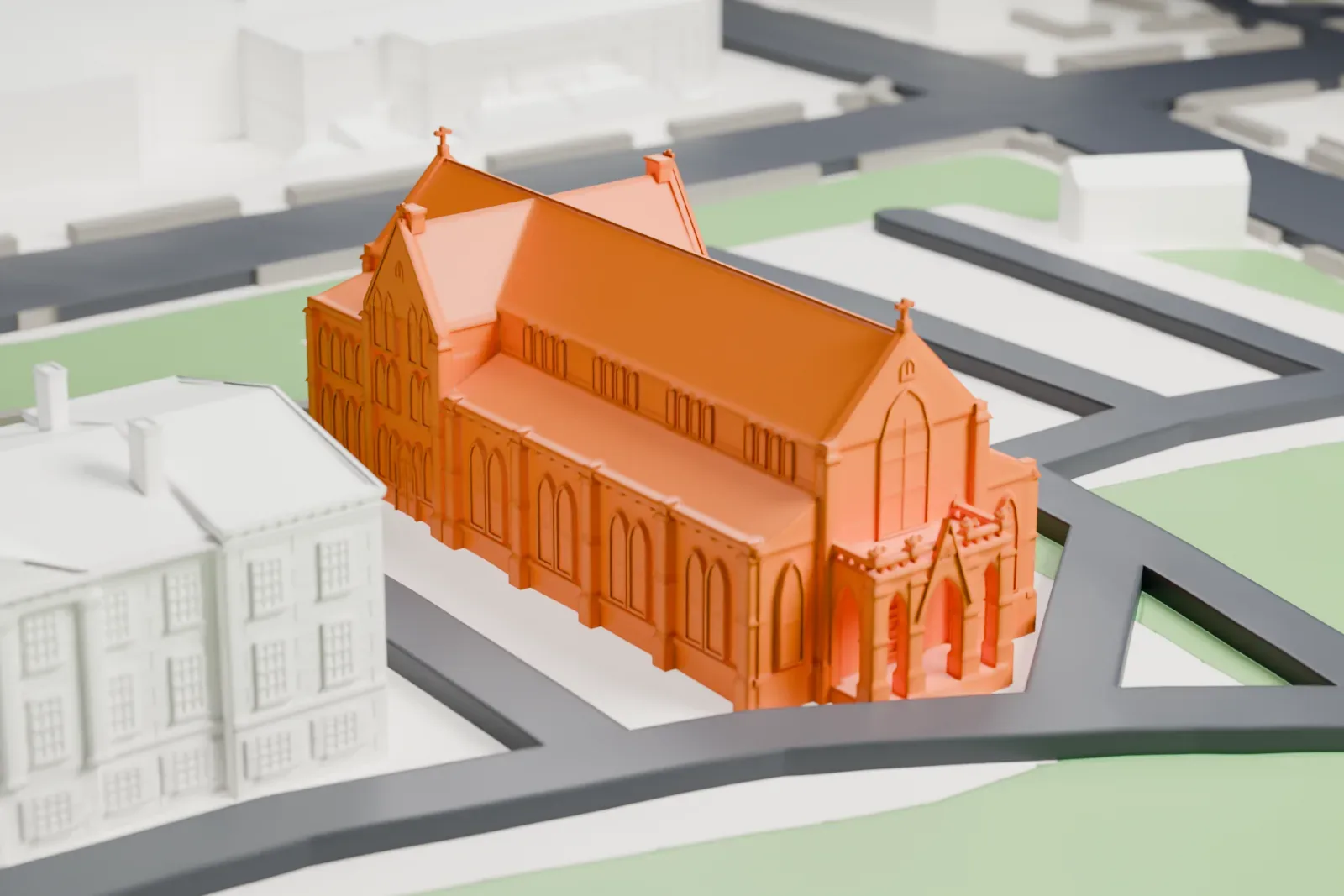 A white 3D print of Kirkpatrick Chapel, a long Gothic-style chapel with a steep roof and a cross gable, standing on a lawn beside curving paths and a neighboring building.