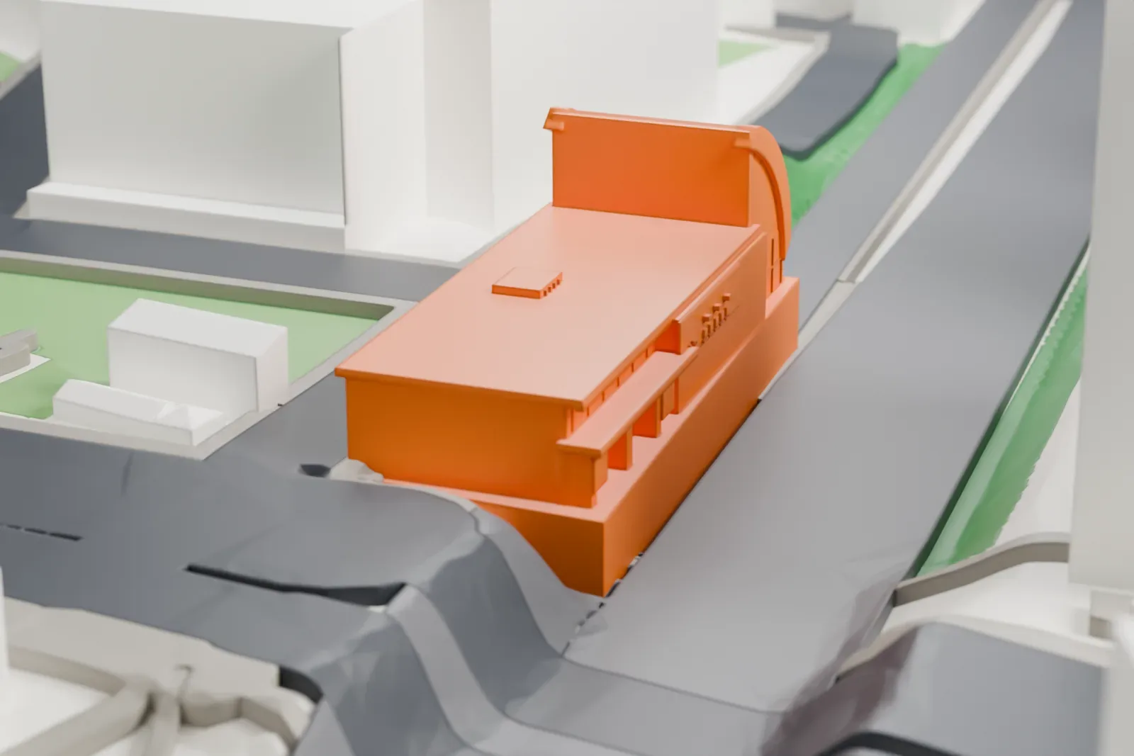 A white 3D print of Komagome Station, a low station building among the surrounding streets and buildings.