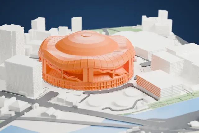 A white 3D print of Kyocera Dome Osaka, a round stadium with a central dome and a wavy roof ring, surrounded by tall buildings, curved roads and water.