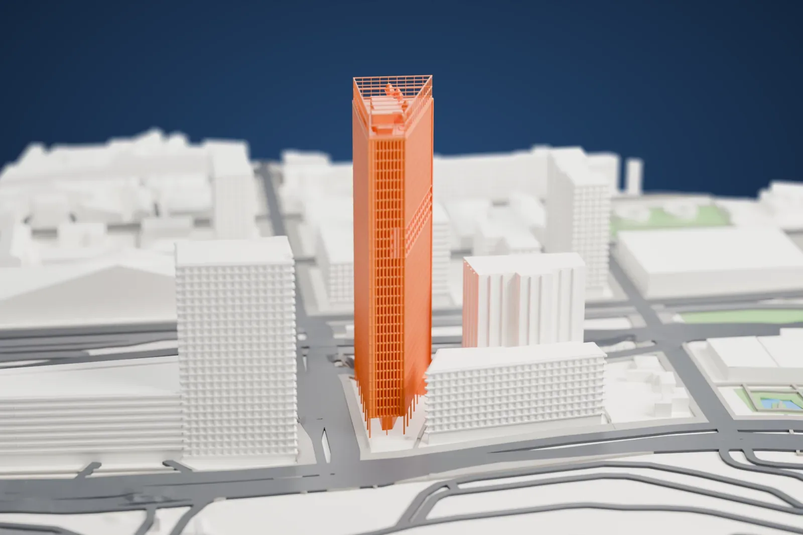A white 3D print of La Marseillaise, a tall rectangular tower with a fine facade grid and an open frame on its roof, among other buildings and roads.