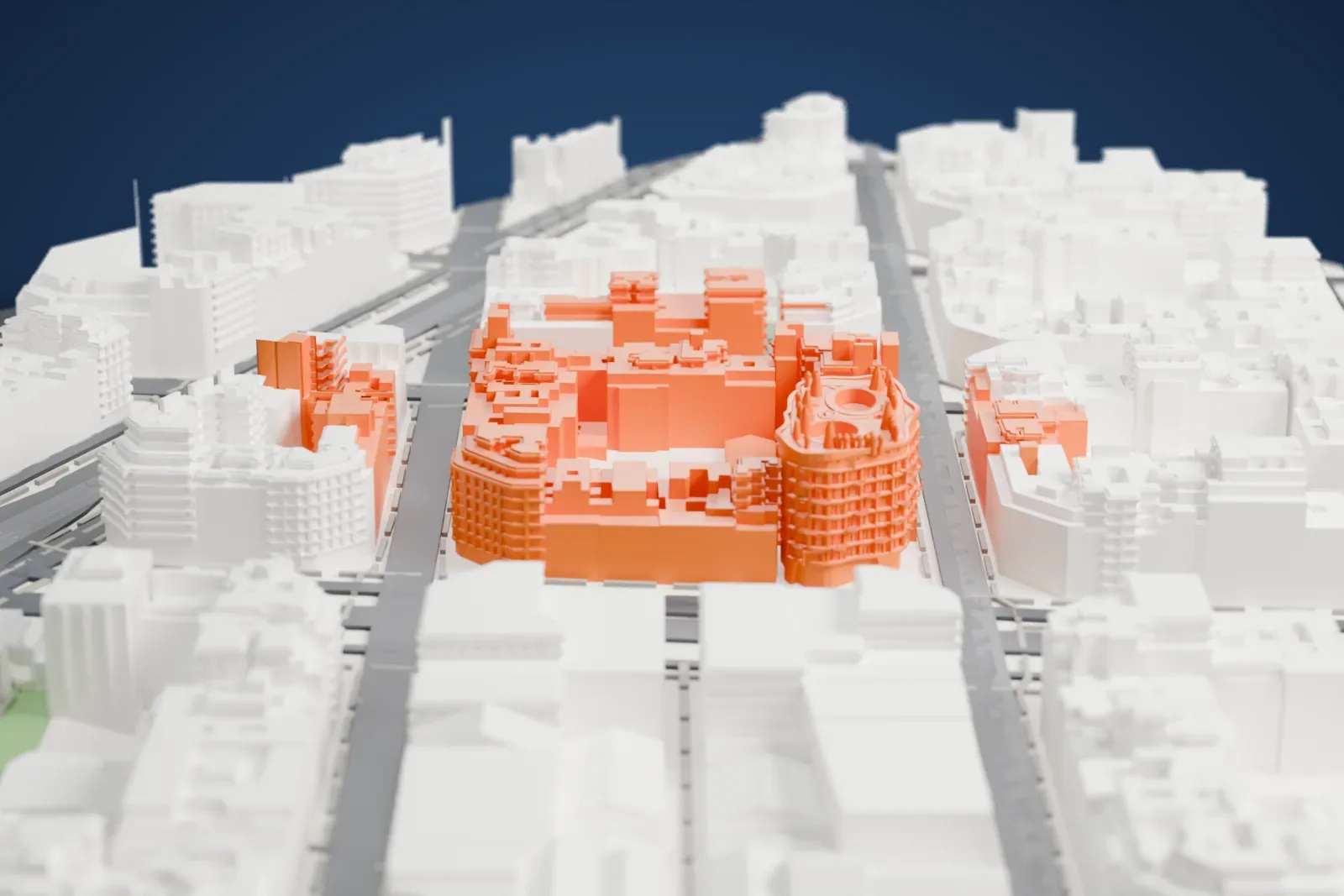 A white 3D print of La Pedrera, a curving building with a wavy facade, balconies and a roof crowded with small chimneys around two round openings, among dense city buildings.
