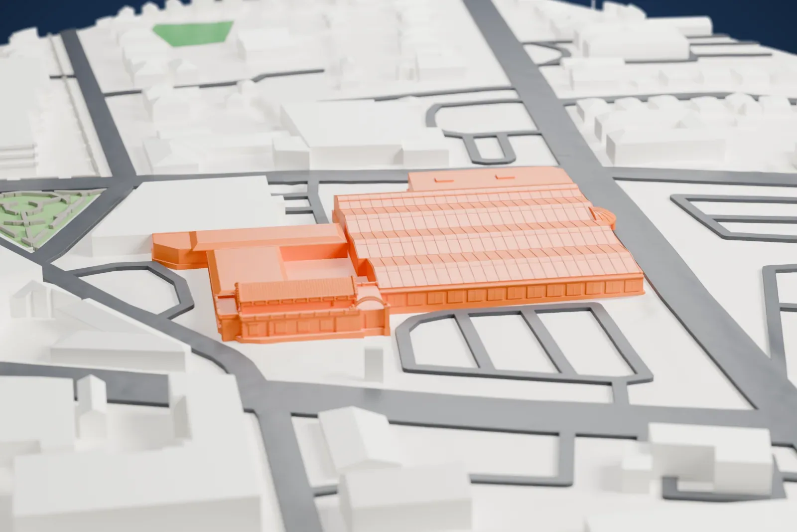 A white 3D print of Lackawanna Terminal, a long station with rows of ridged shed roofs and a decorated entrance pavilion, among wide streets and low buildings.