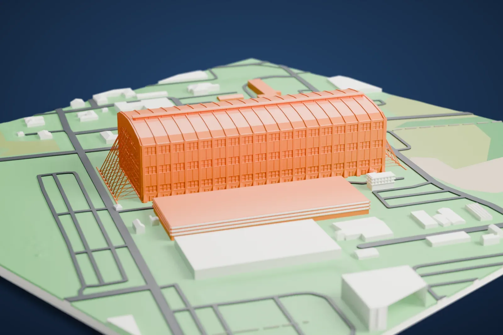 A white 3D print of Lakehurst Hangar No. 1, a very long arched hangar with a ribbed barrel roof, surrounded by lawns, roads and low buildings.