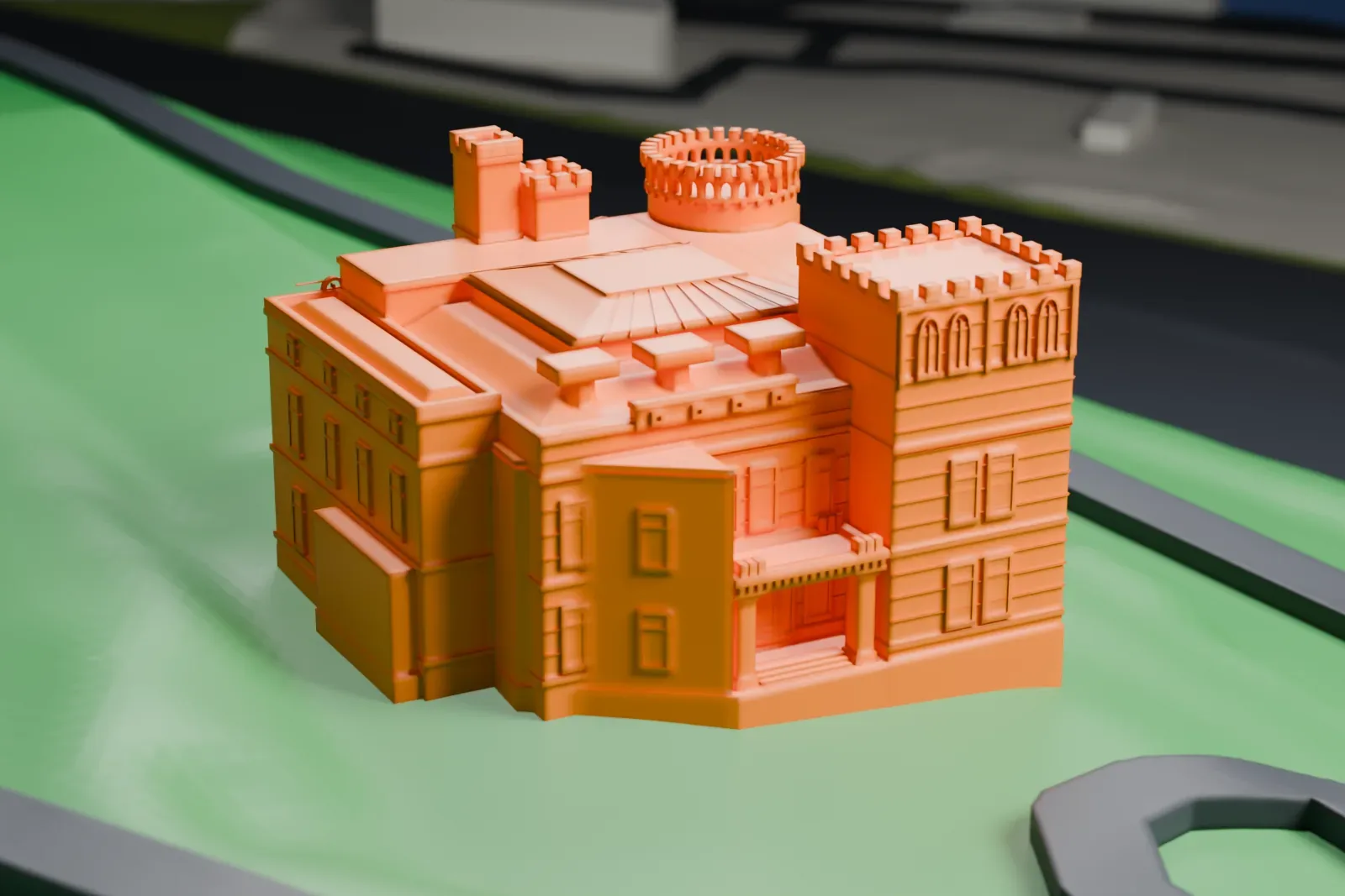 A white 3D print of Lambert Castle, a castle-like house with a round crenellated tower and battlements, on green ground with a road curving nearby.