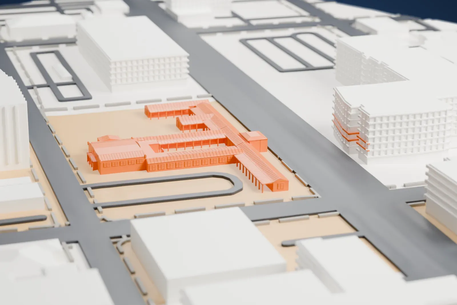 A white 3D print of the Historic Fifth Street School, a low school with several wings and long covered walkways around a driveway loop, among larger downtown buildings.
