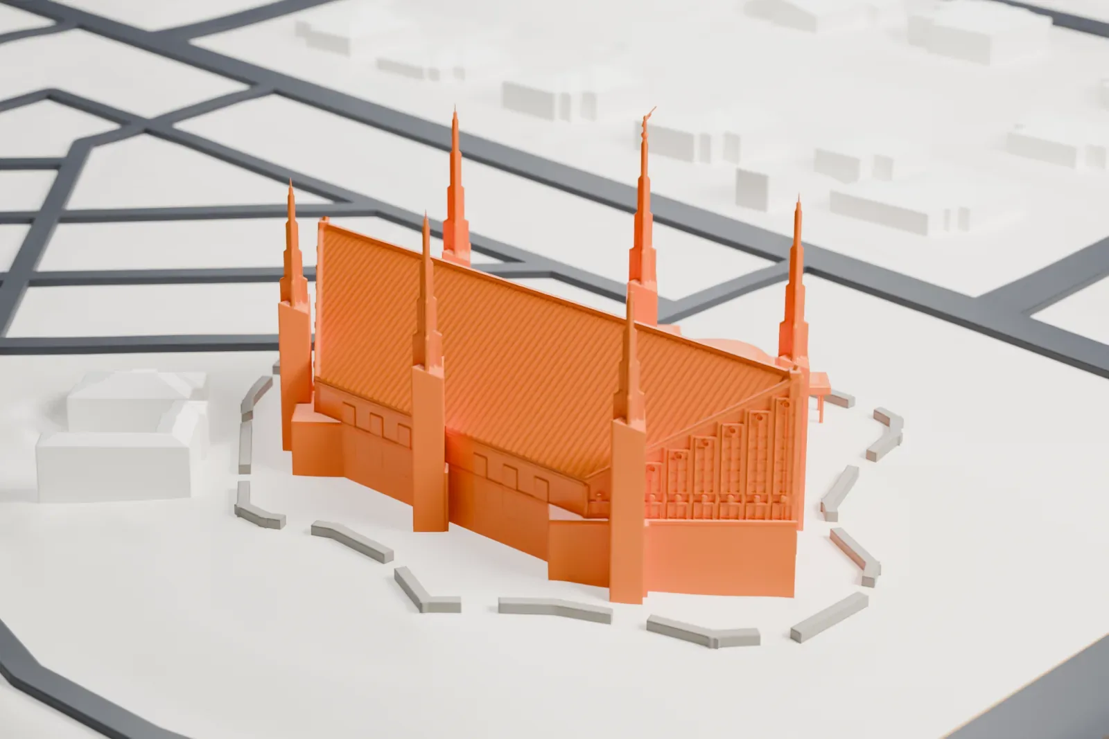 A white 3D print of the Las Vegas Nevada Temple, a building with six slender spires and a steep roof, on open ground among streets and low buildings.