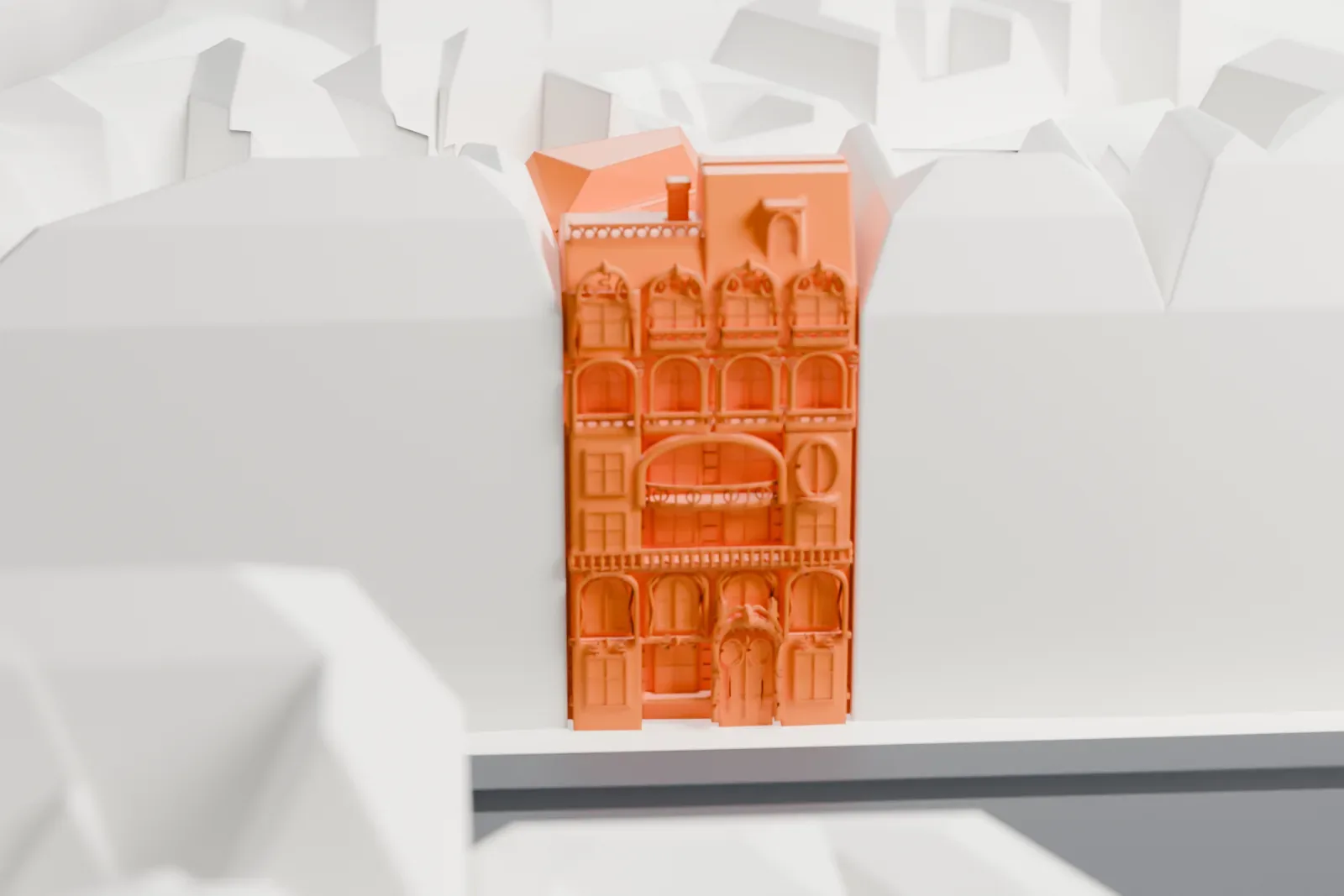 A white 3D print of the Lavirotte Building, its decorated facade rising among the surrounding Paris streets and buildings.