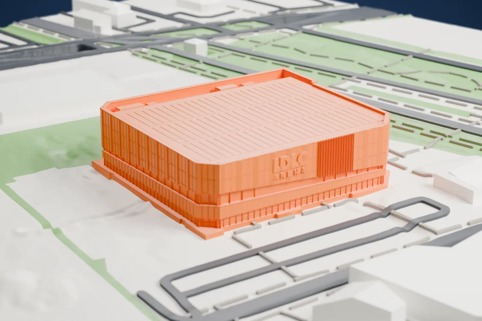 A white 3D print of the LDLC Arena, a wide hall with a ribbed flat roof and a lower annex beside it, surrounded by open ground, roads and a few low buildings.