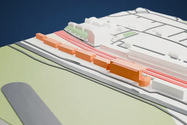A white 3D print of the Pit Building, Circuit des 24 Heures du Mans model in Le Mans, with the streets around it.