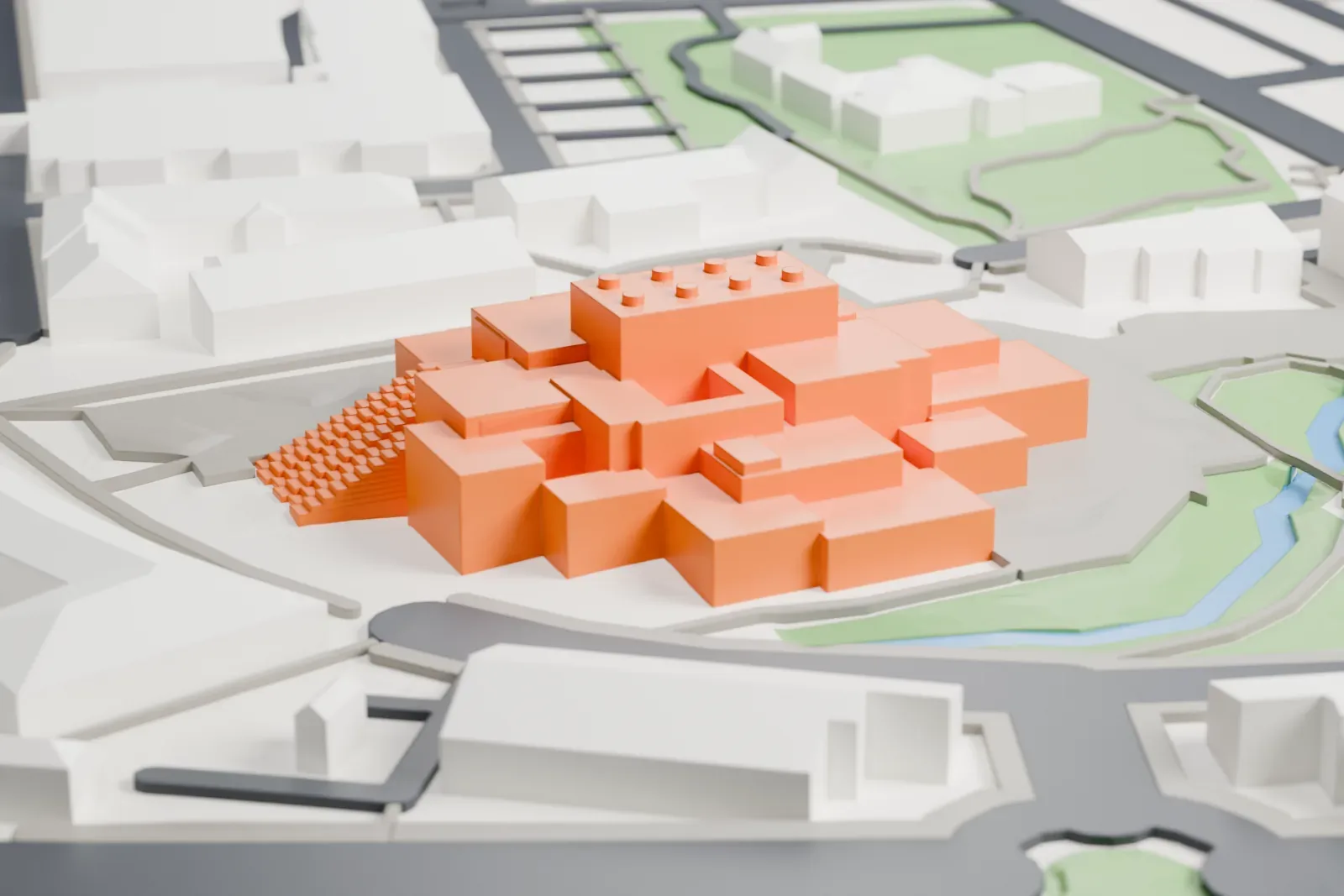 A white 3D print of LEGO House, a stack of offset white blocks, standing in the town of Billund.